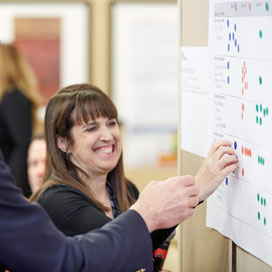 MCA council member putting a sticker on a white graph