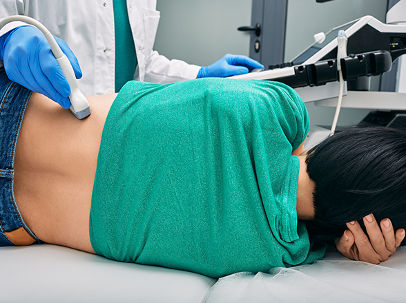 A person lying down getting an ultrasound on their back