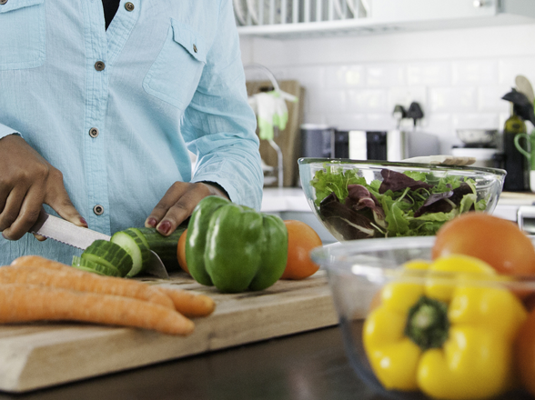 A person chopping vegetables in a kitchen