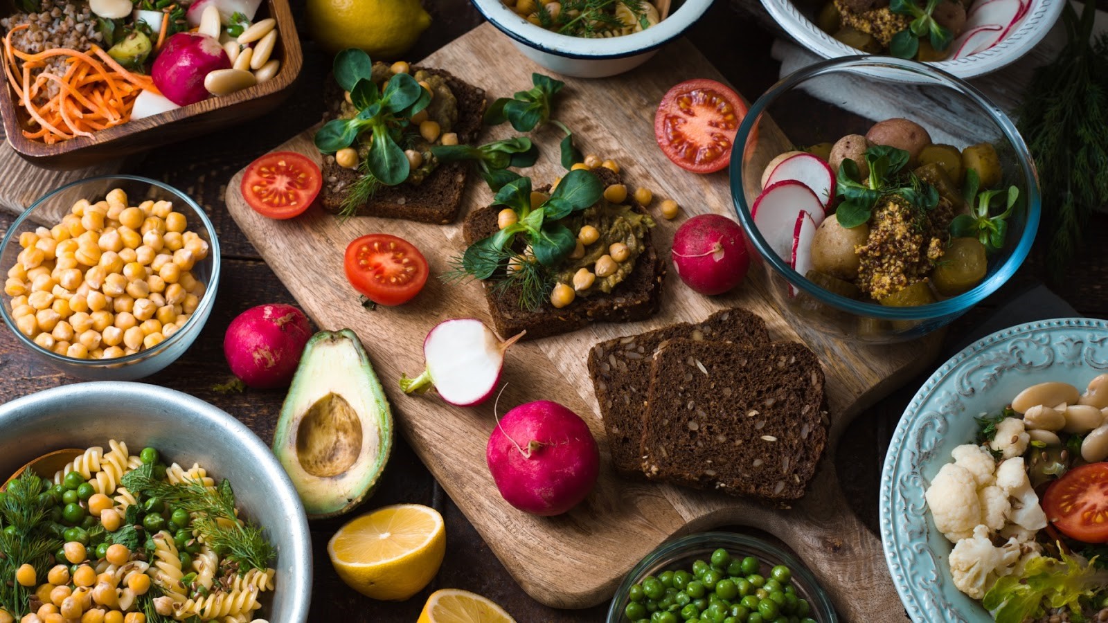 Different salads and snacks on the wooden table.