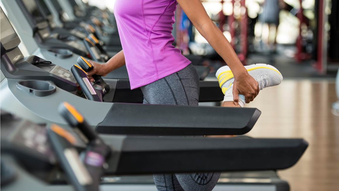 Woman stretching her legs on treadmill 