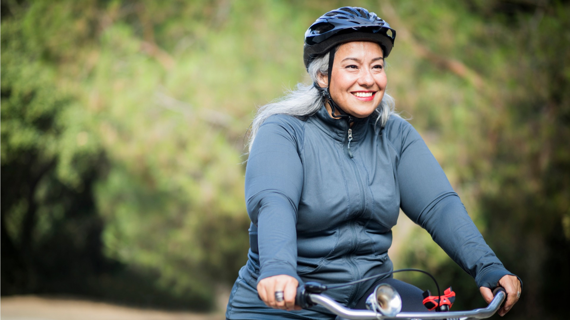 woman wearing helmet riding bicycle outdoors