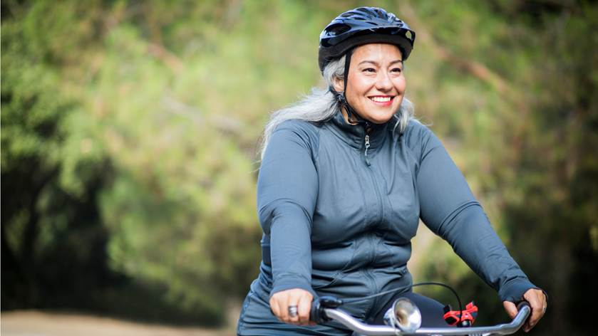 woman wearing helmet riding bicycle outdoors
